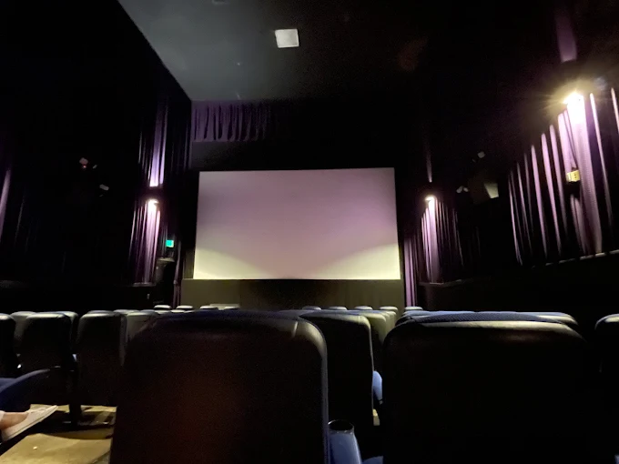 A theater interior at Village Theaters, Big Bear Lake, featuring rows of chairs facing a large screen.