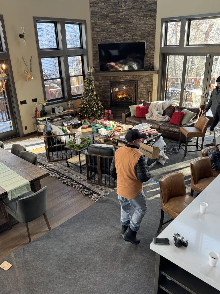 A man stands in the center of a living room, part of the Kim Lansell Production in Big Bear.