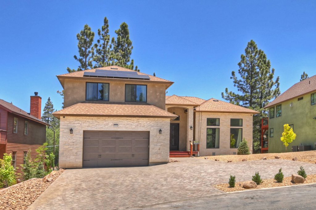 Villa Felicita exterior with solar panels, spacious driveway, and modern mountain design