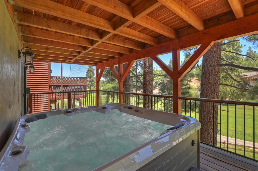 An outdoor hot tub on a covered deck at a cabin in Big Bear.