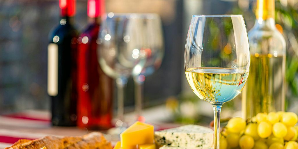 A table set with wine and cheese, accompanied by bottles of wine, at the Big Bear Lake Village Wine Walk event.
